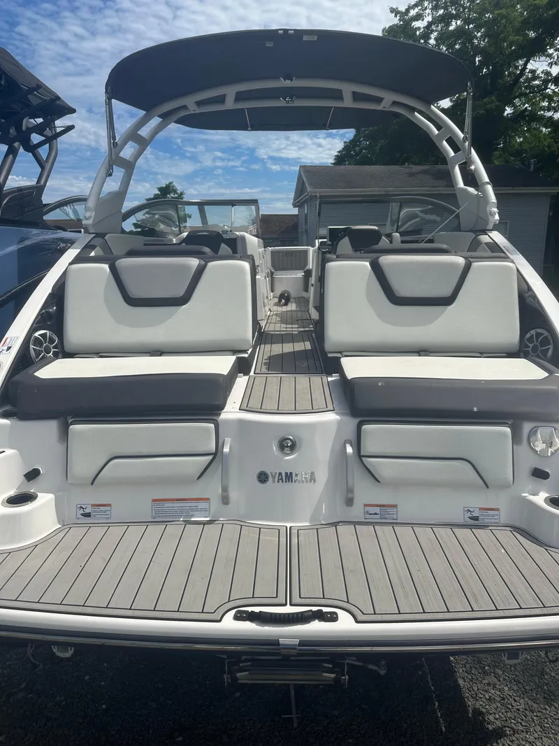 Slide: The Image of 2021 Yamaha Boats 252S with sleek seating and modern design under a clear sky. - 5
