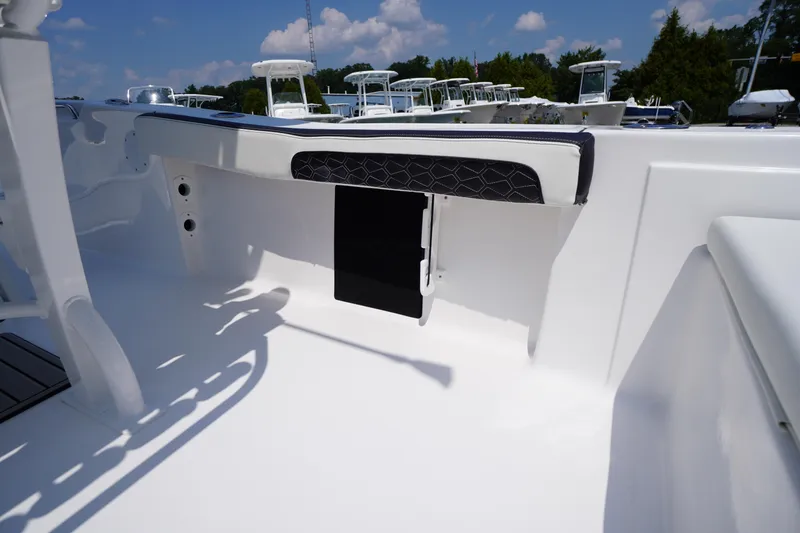 Slide: The Image of 2026 Tidewater 198 CC Adventure boat interior with cushioned seating and storage compartment. - 34
