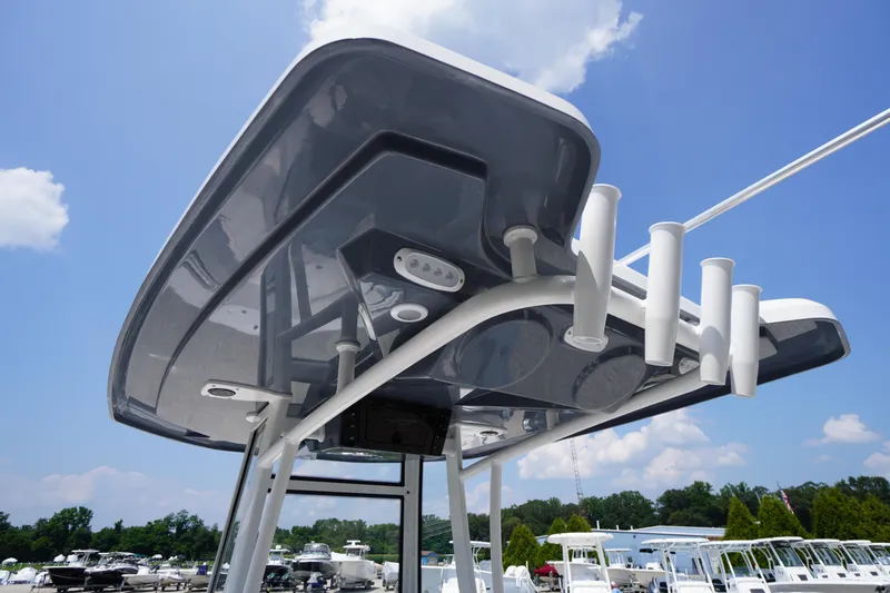Slide: The Image of 2026 Tidewater 198 CC Adventure boat's T-top with rod holders under clear blue sky. - 41