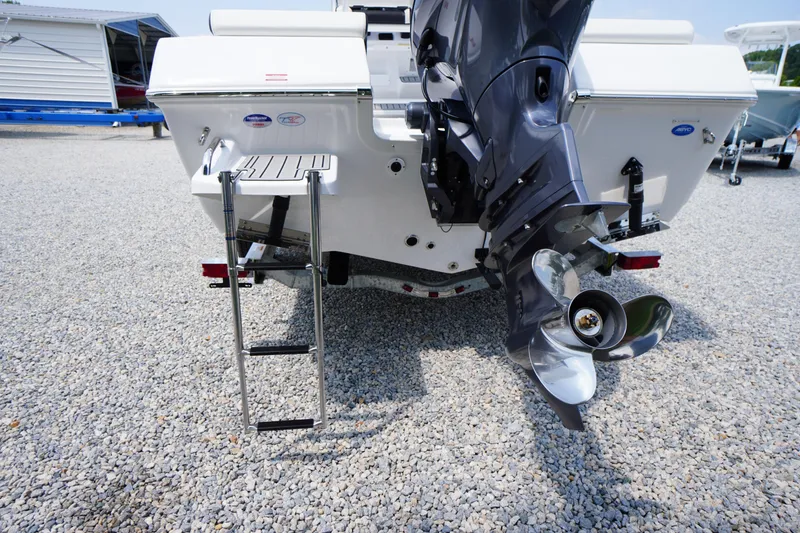 Slide: The Image of 2026 Tidewater 198 CC Adventure boat with ladder and outboard motor on gravel surface. - 45