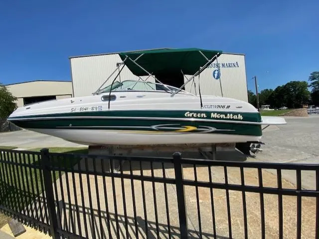 Slide: The Image of 2006 Four Winns 244 Funship boat with green canopy, docked at a marina. - 2