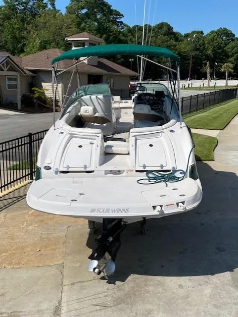 Slide: The Image of 2006 Four Winns 244 Funship boat parked on driveway, green canopy, residential background. - 3