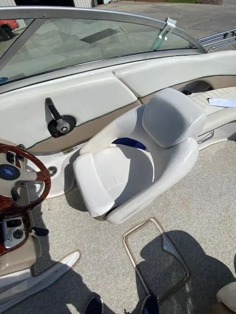 Slide: The Image of Interior of 2006 Four Winns 244 Funship boat with white seating and steering wheel. - 6