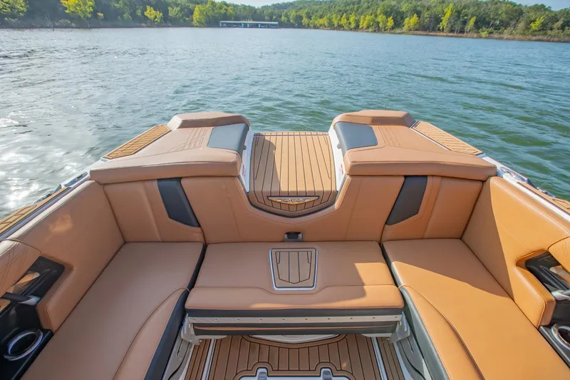 Slide: The Image of 2020 Nautique Super Air Nautique G25 boat interior with tan seating on a lake. - 11