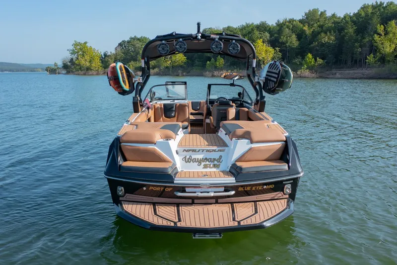 Slide: The Image of 2020 Nautique Super Air Nautique G25 boat on a lake, surrounded by trees. - 2