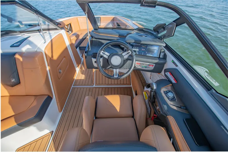 Slide: The Image of 2020 Nautique Super Air Nautique G25 boat interior with modern dashboard and tan seating. - 20