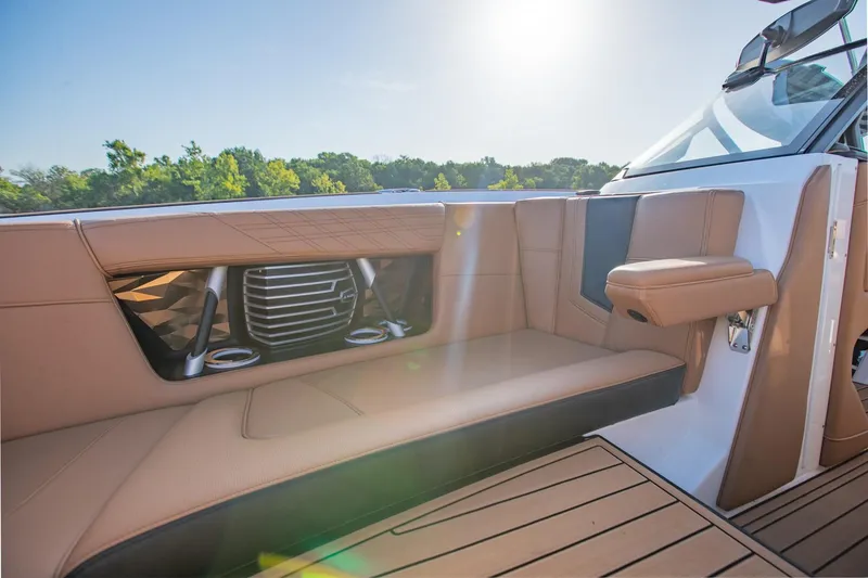 Slide: The Image of 2020 Nautique Super Air Nautique G25 interior with tan seating and cup holders. - 27