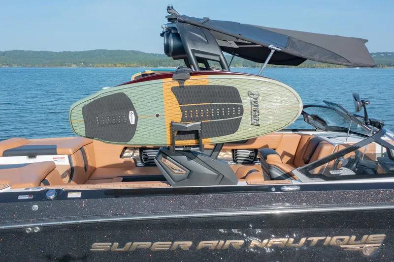 Slide: The Image of 2020 Nautique Super Air Nautique G25 with surfboard on lake. - 8