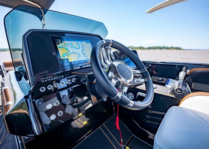 Slide: The Image of Modern Paradigm 236 boat dashboard with navigation screen and steering wheel, 2025 model. - 25