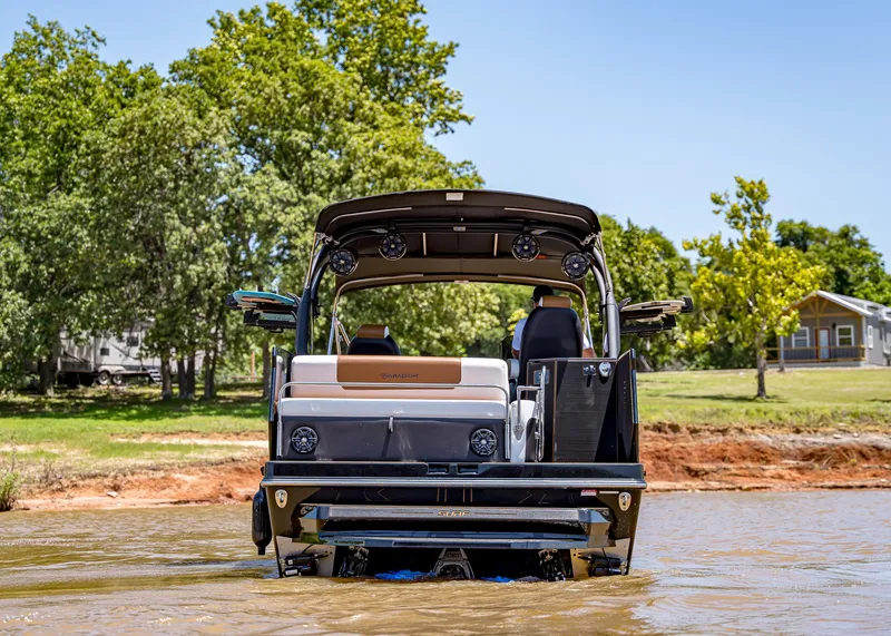 Slide: The Image of 2025 Paradigm 236 boat in shallow water, surrounded by trees and a house. - 4