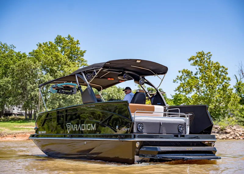 Slide: The Image of 2025 Paradigm 236 boat cruising on a sunny day, surrounded by lush greenery. - 5