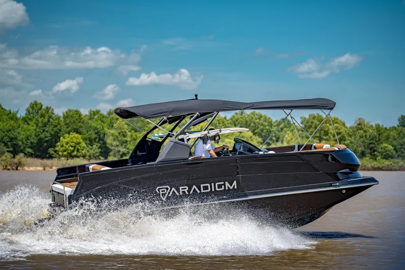 Slide: The Image of 2025 Paradigm 236 boat cruising on a sunny day, surrounded by lush greenery. - 8