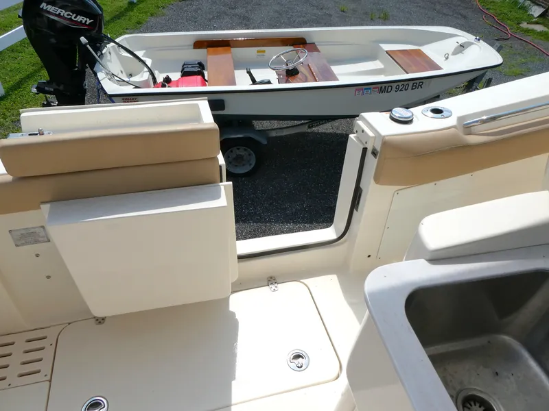 Slide: The Image of 2022 Scout 305 LXF boat interior with sink, open door, and small boat outside. - 10