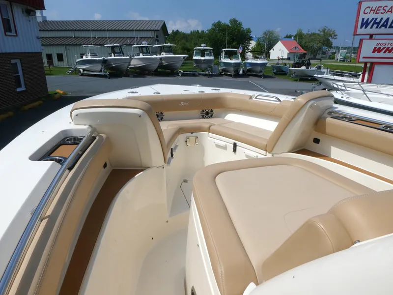 Slide: The Image of 2022 Scout 305 LXF boat interior with tan seating and cup holders. - 11