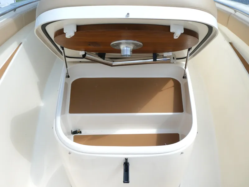 Slide: The Image of 2022 Scout 305 LXF boat storage compartment with open lid, showcasing interior space. - 13