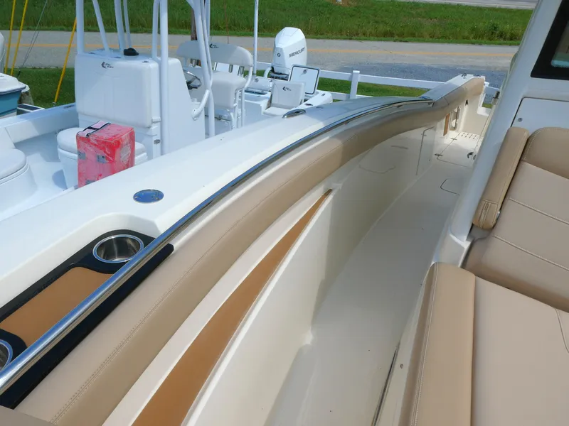 Slide: The Image of 2022 Scout 305 LXF boat interior with beige seating and cup holders. - 14