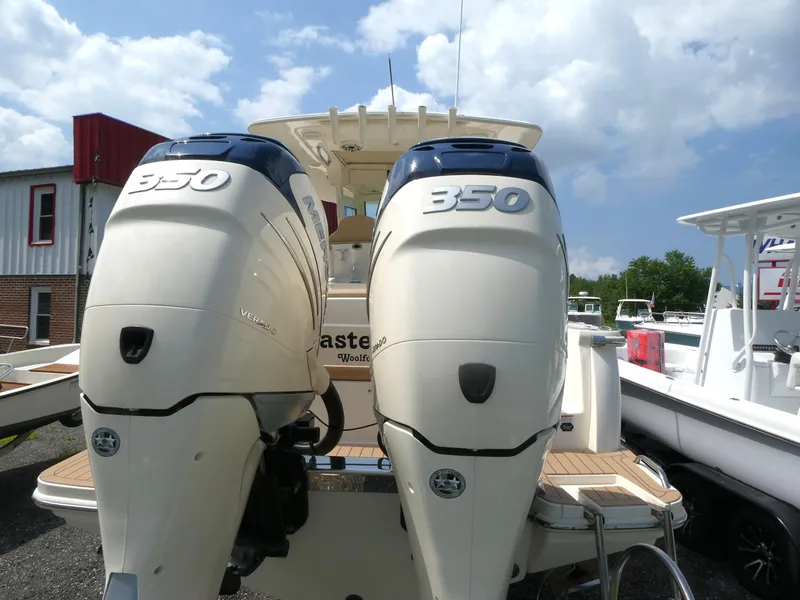 Slide: The Image of 2022 Scout 305 LXF boat with twin 350 horsepower engines, docked under a cloudy sky. - 3