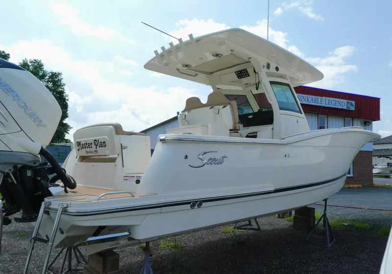 Slide: The Image of 2022 Scout 305 LXF boat on display with Mercury engine, outdoor setting. - 4