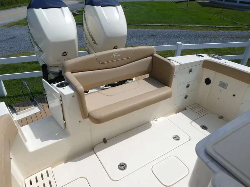 Slide: The Image of 2022 Scout 305 LXF boat interior with beige seating and dual Mercury engines. - 7