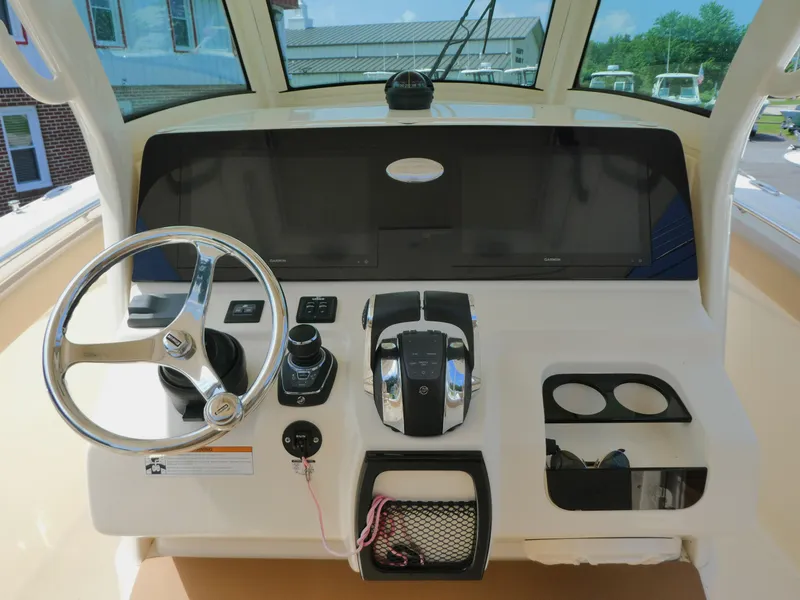 Slide: The Image of 2022 Scout 305 LXF boat dashboard with steering wheel and control panel. - 8