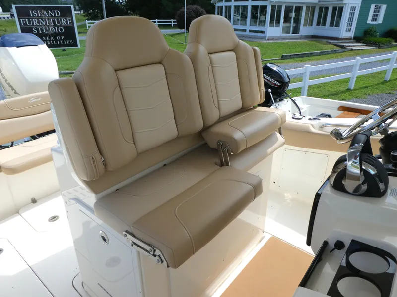 Slide: The Image of 2022 Scout 305 LXF boat interior with beige leather seating and steering console. - 9