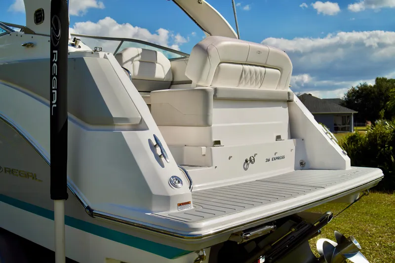 Slide: The Image of 2019 Regal 26 Express boat with spacious deck and seating, under a clear blue sky. - 11
