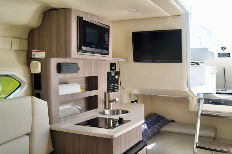 Slide: The Image of 2019 Regal 26 Express boat interior with kitchenette, microwave, and TV. - 29
