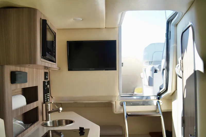 Slide: The Image of Interior of 2019 Regal 26 Express boat with kitchenette and TV. - 30