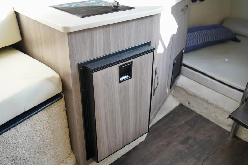 Slide: The Image of 2019 Regal 26 Express cabin interior with compact kitchenette and cozy seating area. - 32
