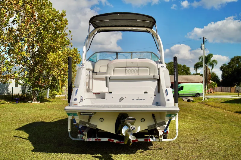 Slide: The Image of 2019 Regal 26 Express boat on trailer, parked on grass under a clear blue sky. - 9