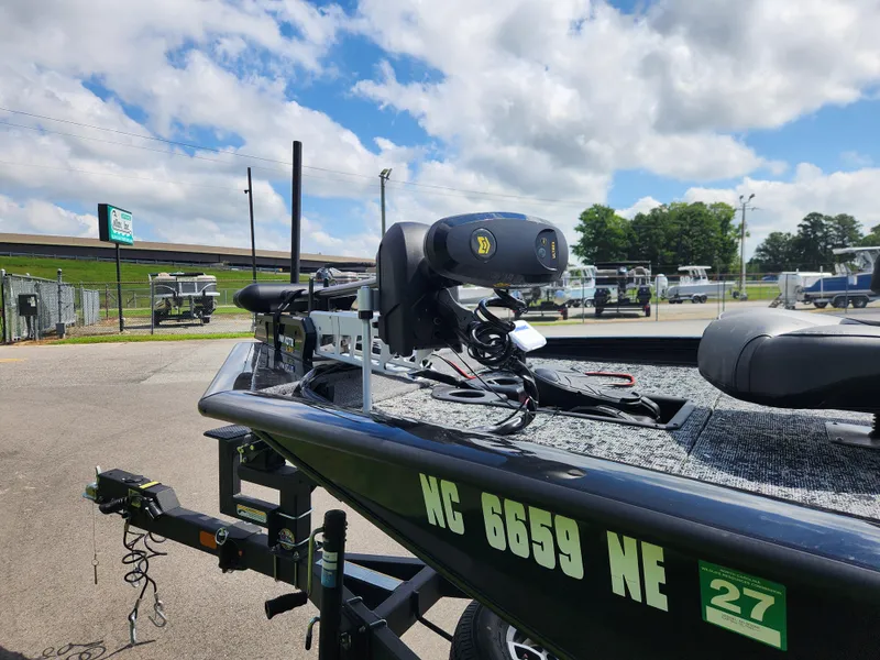 Slide: The Image of 2025 Tracker Pro Team 195 Tournament Edition boat with motor, parked outdoors under a cloudy sky. - 12