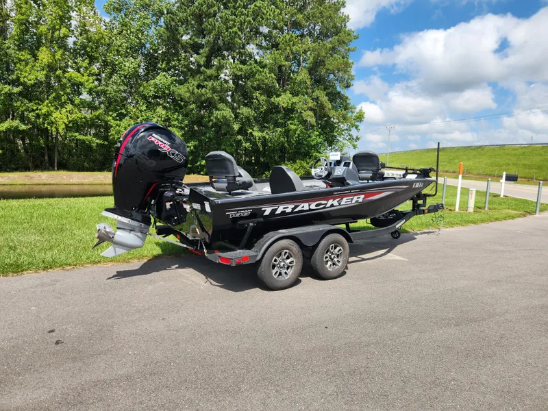 Slide: The Image of 2025 Tracker Pro Team 195 Tournament Edition boat on trailer, parked outdoors. - 2