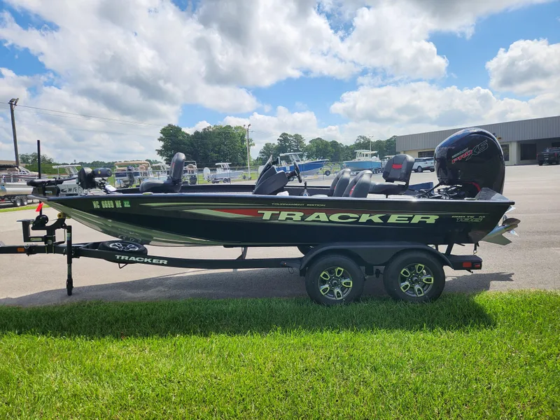 Slide: The Image of 2025 Tracker Pro Team 195 Tournament Edition boat on trailer, parked outdoors under a cloudy sky. - 6