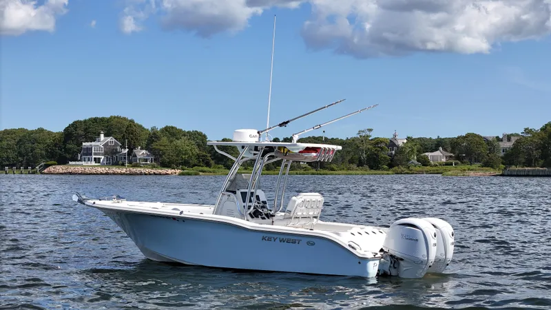 Slide: The Image of 2024 Key West 244 Center Console boat on calm water, scenic background. - 2