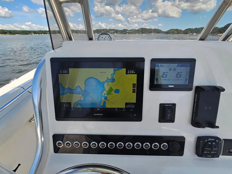 Slide: The Image of 2024 Key West 244 Center Console boat dashboard with Garmin navigation system on open water. - 21