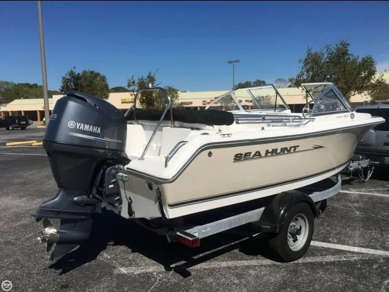 Slide: The Image of 2013 Sea Hunt Escape 188 boat with Yamaha engine on trailer in parking lot. - 2