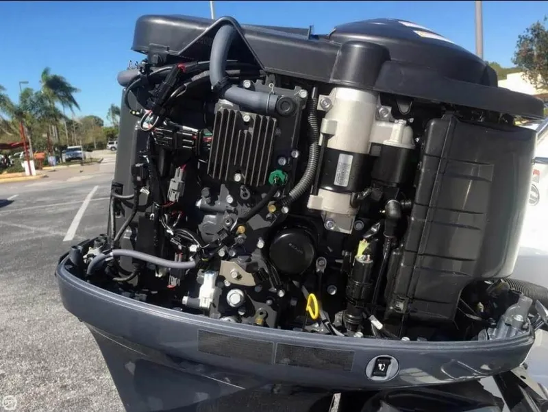 Slide: The Image of 2013 Sea Hunt Escape 188 outboard motor, detailed view in a sunny parking lot. - 9
