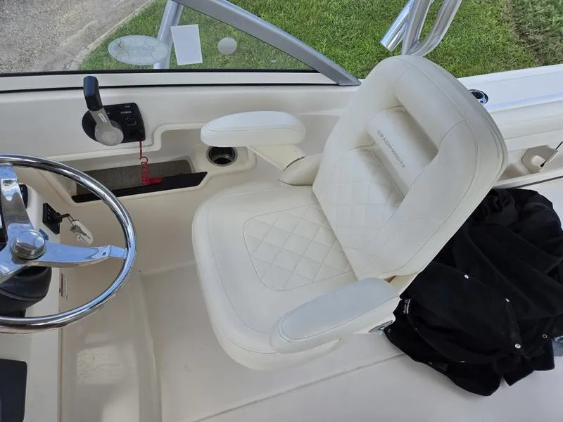 Slide: The Image of Captain's seat on 2019 Grady-White Freedom 235 boat, featuring a steering wheel and controls. - 14