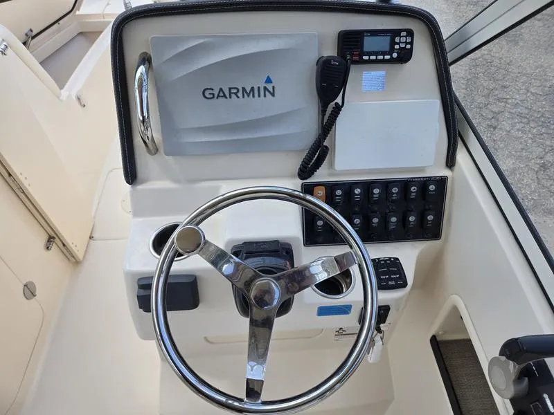 Slide: The Image of 2019 Grady-White Freedom 235 boat dashboard with Garmin navigation system and controls. - 15