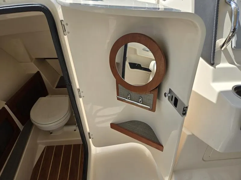 Slide: The Image of 2019 Grady-White Freedom 235 boat interior with compact bathroom and mirror. - 17