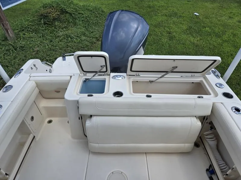 Slide: The Image of 2019 Grady-White Freedom 235 boat interior with open storage compartments and motor. - 5