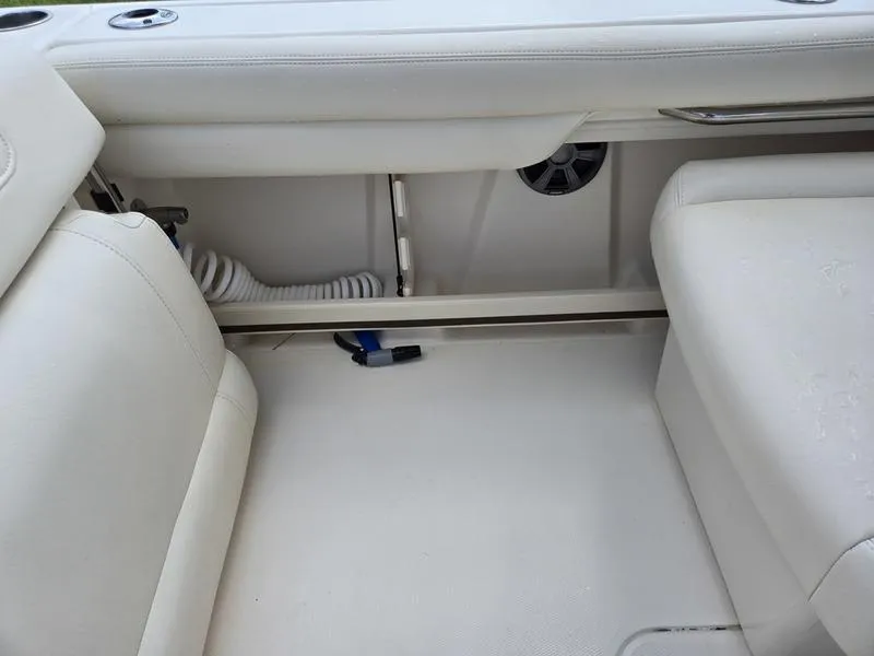 Slide: The Image of 2019 Grady-White Freedom 235 boat interior with white seating and storage area. - 9