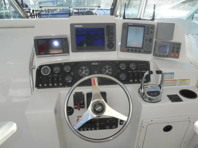 Slide: The Image of Control panel of a 2000 Boston Whaler 34 Defiance boat with steering wheel and navigation instruments. - 15