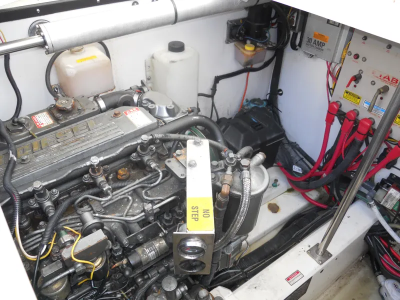 Slide: The Image of Engine compartment of a 2000 Boston Whaler 34 Defiance, featuring diesel engine and electrical components. - 24