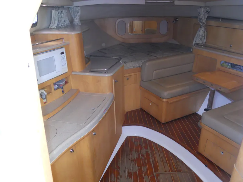 Slide: The Image of Interior of 2000 Boston Whaler 34 Defiance boat with kitchenette and seating area. - 27