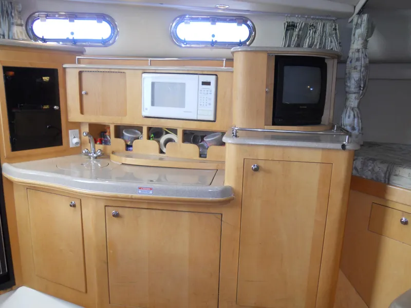 Slide: The Image of Interior of 2000 Boston Whaler 34 Defiance with kitchenette and TV. - 33