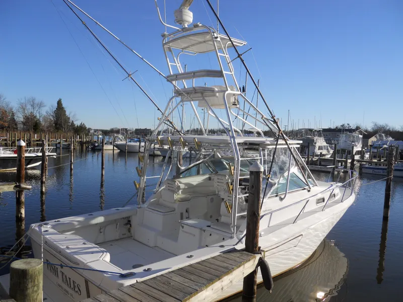 Slide: The Image of Boston Whaler 34 Defiance 2000 docked in a marina under clear blue skies. - 4
