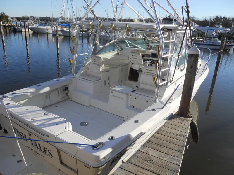 Slide: The Image of 2000 Boston Whaler 34 Defiance boat docked at marina, featuring spacious deck and seating. - 5