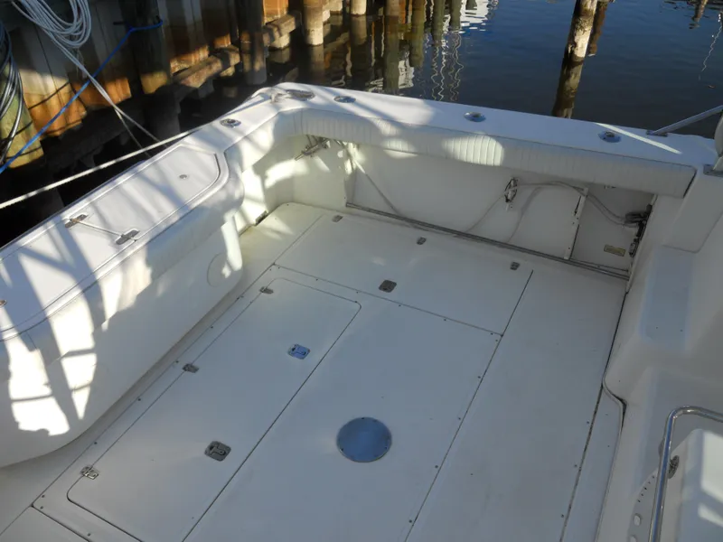 Slide: The Image of Boston Whaler 34 Defiance 2000 boat deck, spacious and clean, docked by wooden pilings. - 8
