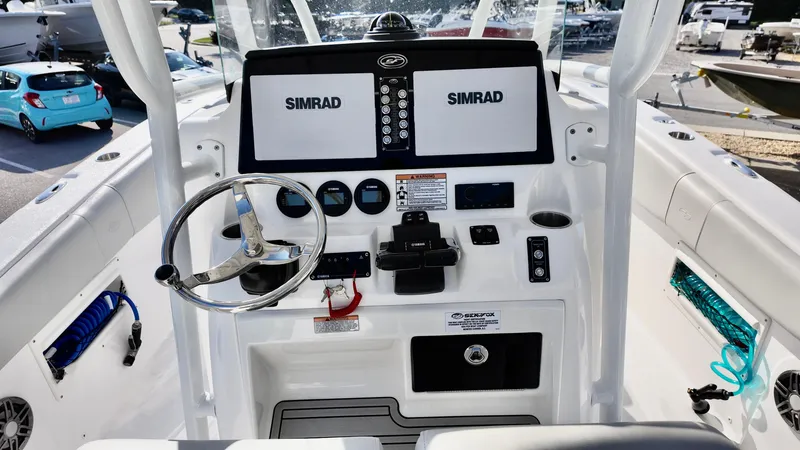 Slide: The Image of 2023 Sea Fox 268 Commander boat dashboard with Simrad displays and steering wheel. - 21